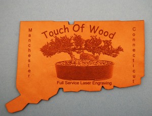 We Laser Engraved Text and a Digital Photograph and Cut the shape of Connecticut shape from a Piece of Leather.
